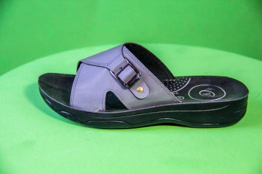 Illustrative Editorial branded photography, Slipper shouted on green Background, shot is selective focus with shallow depth of field. Photos taken at Cairo Egypt on 28 March 2019