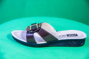 Illustrative Editorial branded photography, Slipper shouted on green Background, shot is selective focus with shallow depth of field. Photos taken at Cairo Egypt on 28 March 2019