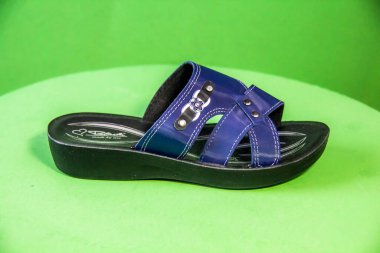 Illustrative Editorial branded photography, Slipper shouted on green Background, shot is selective focus with shallow depth of field. Photos taken at Cairo Egypt on 28 March 2019