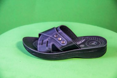 Illustrative Editorial branded photography, Slipper shouted on green Background, shot is selective focus with shallow depth of field. Photos taken at Cairo Egypt on 28 March 2019