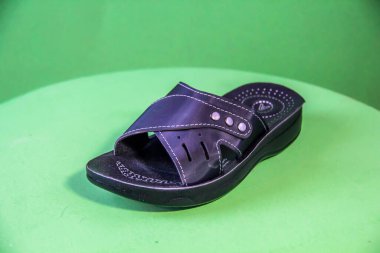 Illustrative Editorial branded photography, Slipper shouted on green Background, shot is selective focus with shallow depth of field. Photos taken at Cairo Egypt on 28 March 2019