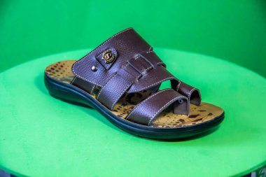 Illustrative Editorial branded photography, Slipper shouted on green Background, shot is selective focus with shallow depth of field. Photos taken at Cairo Egypt on 28 March 2019