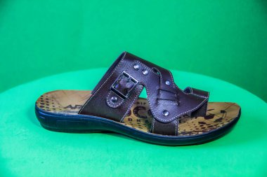 Illustrative Editorial branded photography, Slipper shouted on green Background, shot is selective focus with shallow depth of field. Photos taken at Cairo Egypt on 28 March 2019
