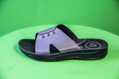 Illustrative Editorial branded photography, Slipper shouted on green Background, shot is selective focus with shallow depth of field. Photos taken at Cairo Egypt on 28 March 2019