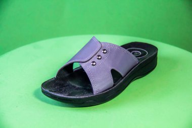 Illustrative Editorial branded photography, Slipper shouted on green Background, shot is selective focus with shallow depth of field. Photos taken at Cairo Egypt on 28 March 2019