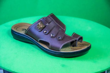 Illustrative Editorial branded photography, Slipper shouted on green Background, shot is selective focus with shallow depth of field. Photos taken at Cairo Egypt on 28 March 2019