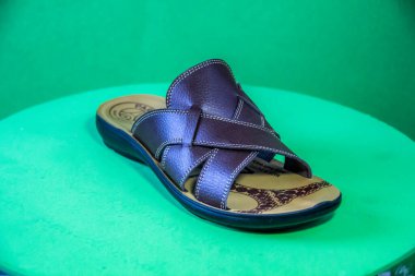 Illustrative Editorial branded photography, Slipper shouted on green Background, shot is selective focus with shallow depth of field. Photos taken at Cairo Egypt on 28 March 2019