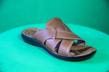Illustrative Editorial branded photography, Slipper shouted on green Background, shot is selective focus with shallow depth of field. Photos taken at Cairo Egypt on 28 March 2019