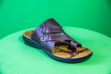 Illustrative Editorial branded photography, Slipper shouted on green Background, shot is selective focus with shallow depth of field. Photos taken at Cairo Egypt on 28 March 2019