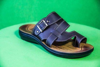 Illustrative Editorial branded photography, Slipper shouted on green Background, shot is selective focus with shallow depth of field. Photos taken at Cairo Egypt on 28 March 2019