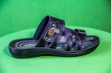 Illustrative Editorial branded photography, Slipper shouted on green Background, shot is selective focus with shallow depth of field. Photos taken at Cairo Egypt on 28 March 2019