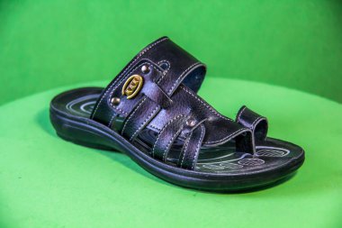 Illustrative Editorial branded photography, Slipper shouted on green Background, shot is selective focus with shallow depth of field. Photos taken at Cairo Egypt on 28 March 2019