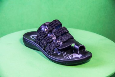 Illustrative Editorial branded photography, Slipper shouted on green Background, shot is selective focus with shallow depth of field. Photos taken at Cairo Egypt on 28 March 2019