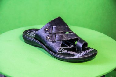 Illustrative Editorial branded photography, Slipper shouted on green Background, shot is selective focus with shallow depth of field. Photos taken at Cairo Egypt on 28 March 2019
