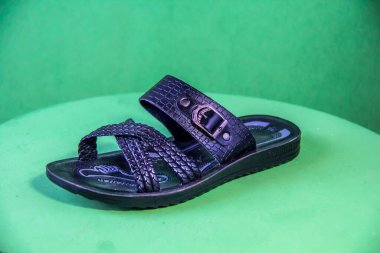 Illustrative Editorial branded photography, Slipper shouted on green Background, shot is selective focus with shallow depth of field. Photos taken at Cairo Egypt on 28 March 2019