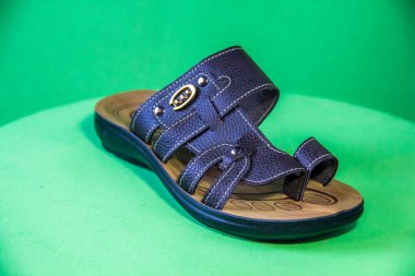 Illustrative Editorial branded photography, Slipper shouted on green Background, shot is selective focus with shallow depth of field. Photos taken at Cairo Egypt on 28 March 2019