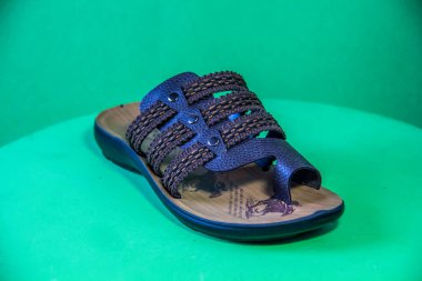 Illustrative Editorial branded photography, Slipper shouted on green Background, shot is selective focus with shallow depth of field. Photos taken at Cairo Egypt on 28 March 2019