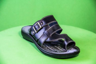 Illustrative Editorial branded photography, Slipper shouted on green Background, shot is selective focus with shallow depth of field. Photos taken at Cairo Egypt on 28 March 2019