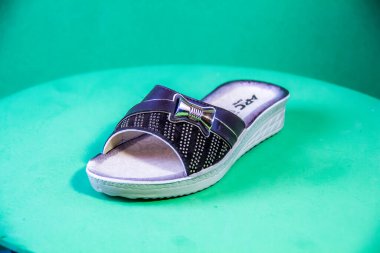 Illustrative Editorial branded photography, Slipper shouted on green Background, shot is selective focus with shallow depth of field. Photos taken at Cairo Egypt on 28 March 2019