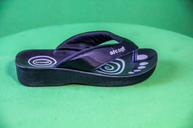 Illustrative Editorial branded photography, Slipper shouted on green Background, shot is selective focus with shallow depth of field. Photos taken at Cairo Egypt on 28 March 2019