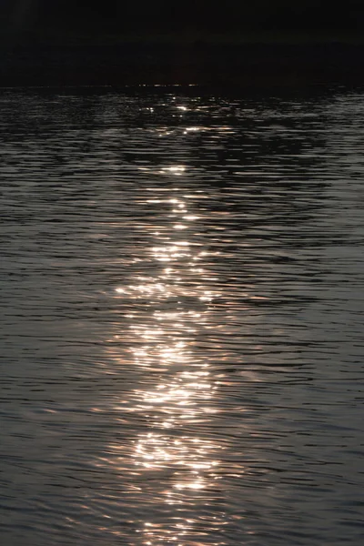 reflection of sinking sun over water