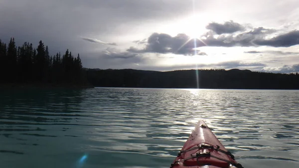 kayaking on a lake into the rising sun