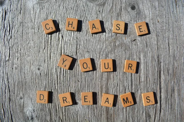 Motivational scrabble word art on old wood backing