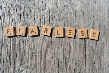 Motivational scrabble word art on old wood backing