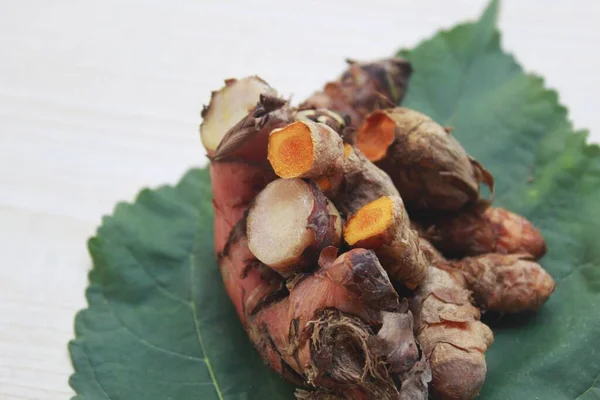 A pile of natural galangal and turmeric roots