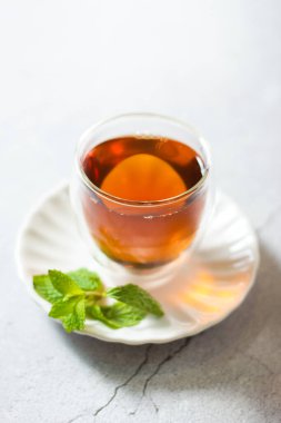 Lezzetli bir fincan siyah tae ve taze nane yaprakları masada, yakın çekim manzaralı..