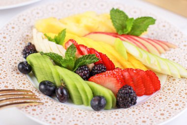 Meyve tabağı, elma, ananas, muz, kivi, böğürtlen, çilek, meyve parçalarını tabakta karıştır.