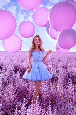 Lavanta tarlasında pembe balonları olan güzel kadın.