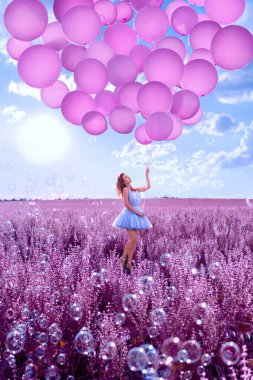Lavanta tarlasında pembe balonları olan güzel kadın.