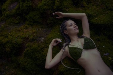 Beautiful woman near moss waterfall