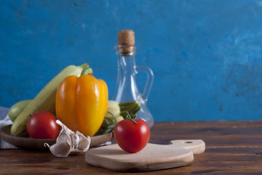 raw mediterranean vegetables ant herbs on wooden table