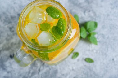 ice orange mojito style beverage on blue background