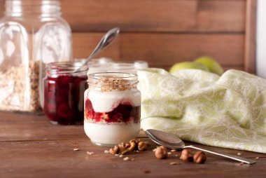 yoghurt and granola on wooden background