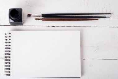 paper, ink, calligraphy pen on white wooden table