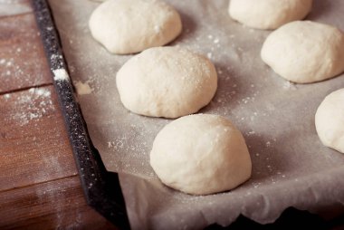 raw homemade hamburger rolls ready to be baked