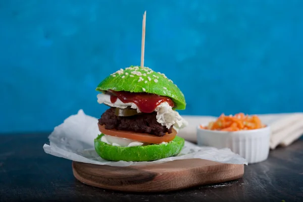 green home made burger on dark blue background
