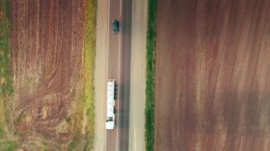 Vertical plan from above on the highway with cars. Road between fields. 4K
