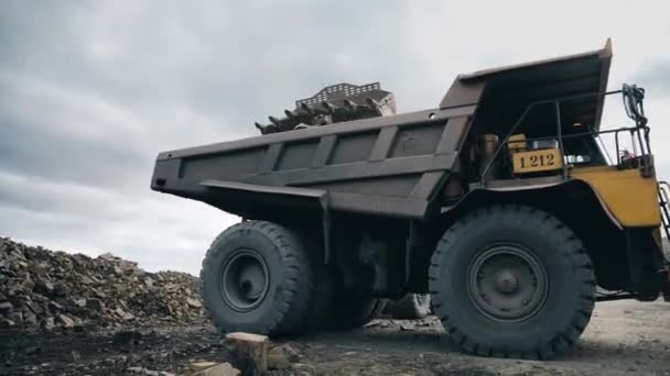 Large Yellow Dump Track Drives Yellow Excavator Raised Bucket Quarry — Vídeos de Stock