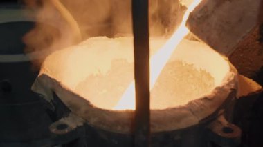 Molten metal is poured into the melting pot. Close-up. Metallurgy. Steelworks. 4K 