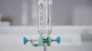 Boiling water in a glass flask. Bubbles. Close-up. Chemical reaction. Bright laboratory. Vertical panorama. Camera moves from bottom to top. 4K