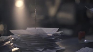 Paper sheets on a steel spoke. A man's hand attaches completed tasks of the workshop to the spoke. Completed checks. Close-up. List of tasks for the factory. 4K