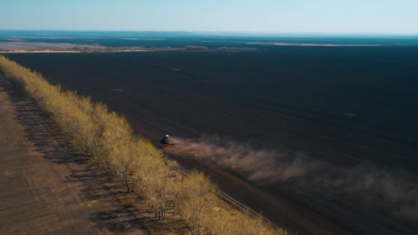 Трактор Проходит Через Черное Поле Лучах Заходящего Солнца Пыль Освещаемая — стоковое видео