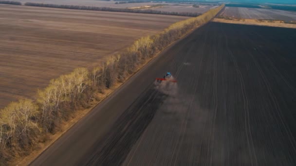 Egy Kék Traktor Piros Borjúval Áthajt Egy Fekete Mezőn Vágás — Stock videók