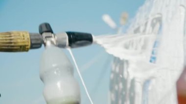 Traktörü yüksek basınçlı çamaşır makinesiyle temizliyorum. Çamaşır makinesinden köpük çıkıyor. Ağır çekim. Deterjan konteynırına yakın çekim. 4K
