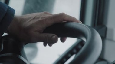 Kamyoncunun elini direksiyonun üzerine yakın plan çek. Kış yolu. Uzun bir yolculuk. 4K
