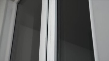 Close-up of a window with a white window frame. Bright room. Darkness outside the window. Room interior. 4K